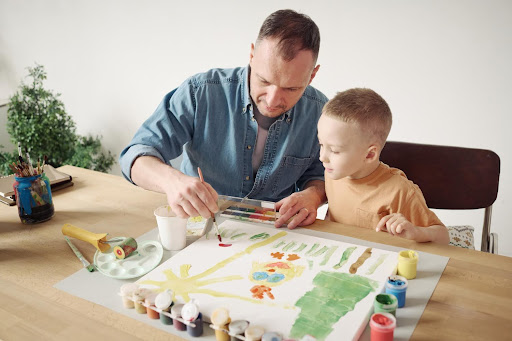 Father and kid are painting.